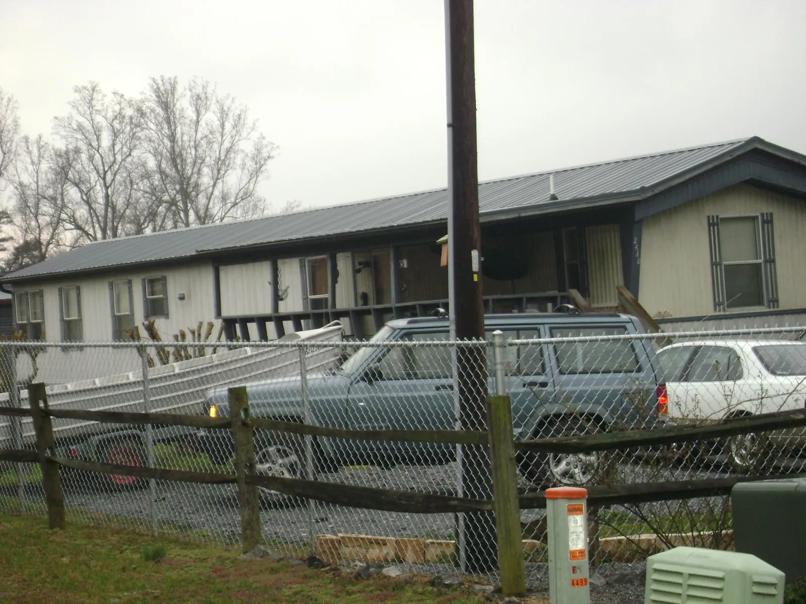 Dark metal roof on a long single story building behind a chain link fence in Savannah